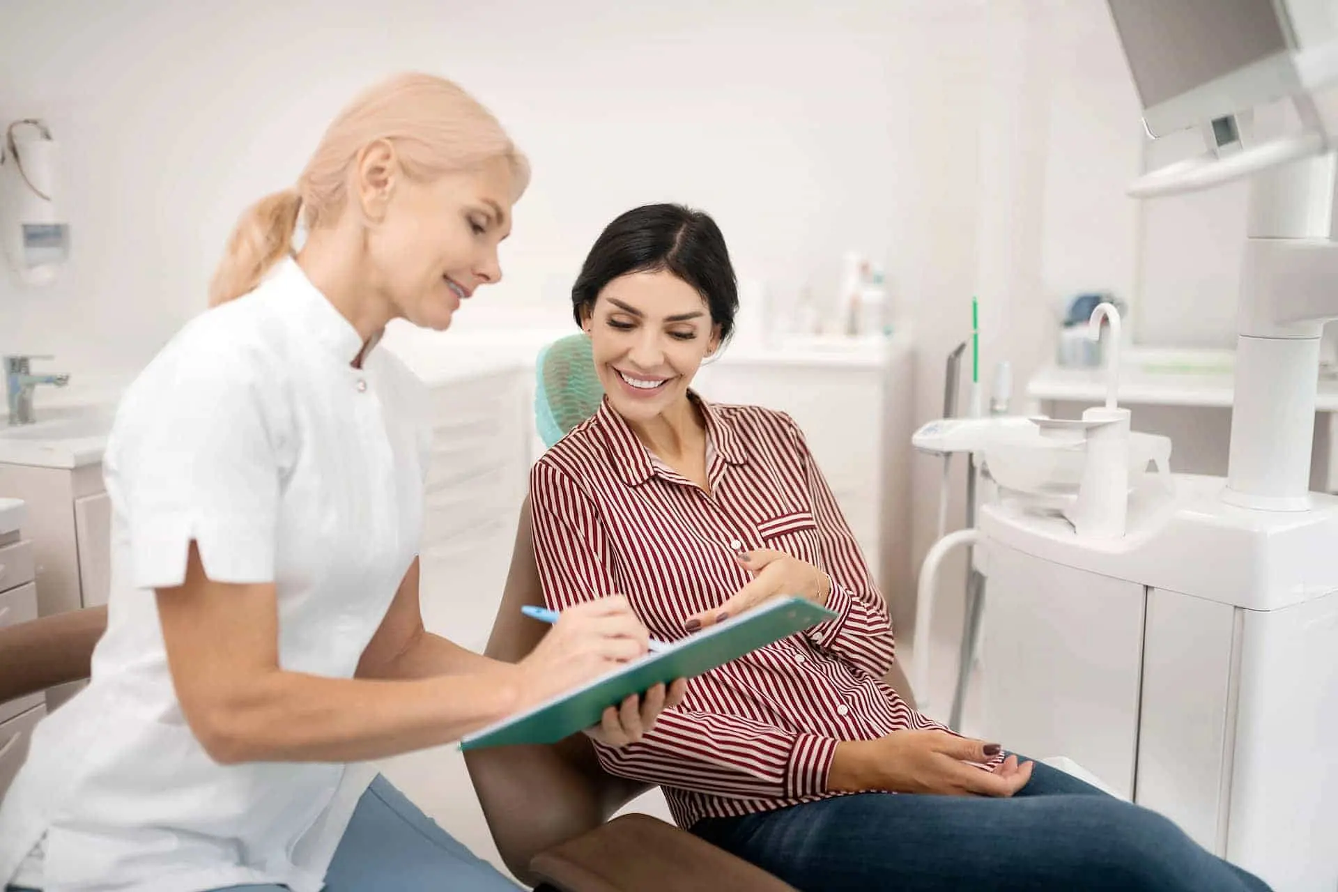 At Holt Orthodontics in Twinsburg, OH, a dentist discusses affordable Invisalign options with a patient in a bright, modern office.