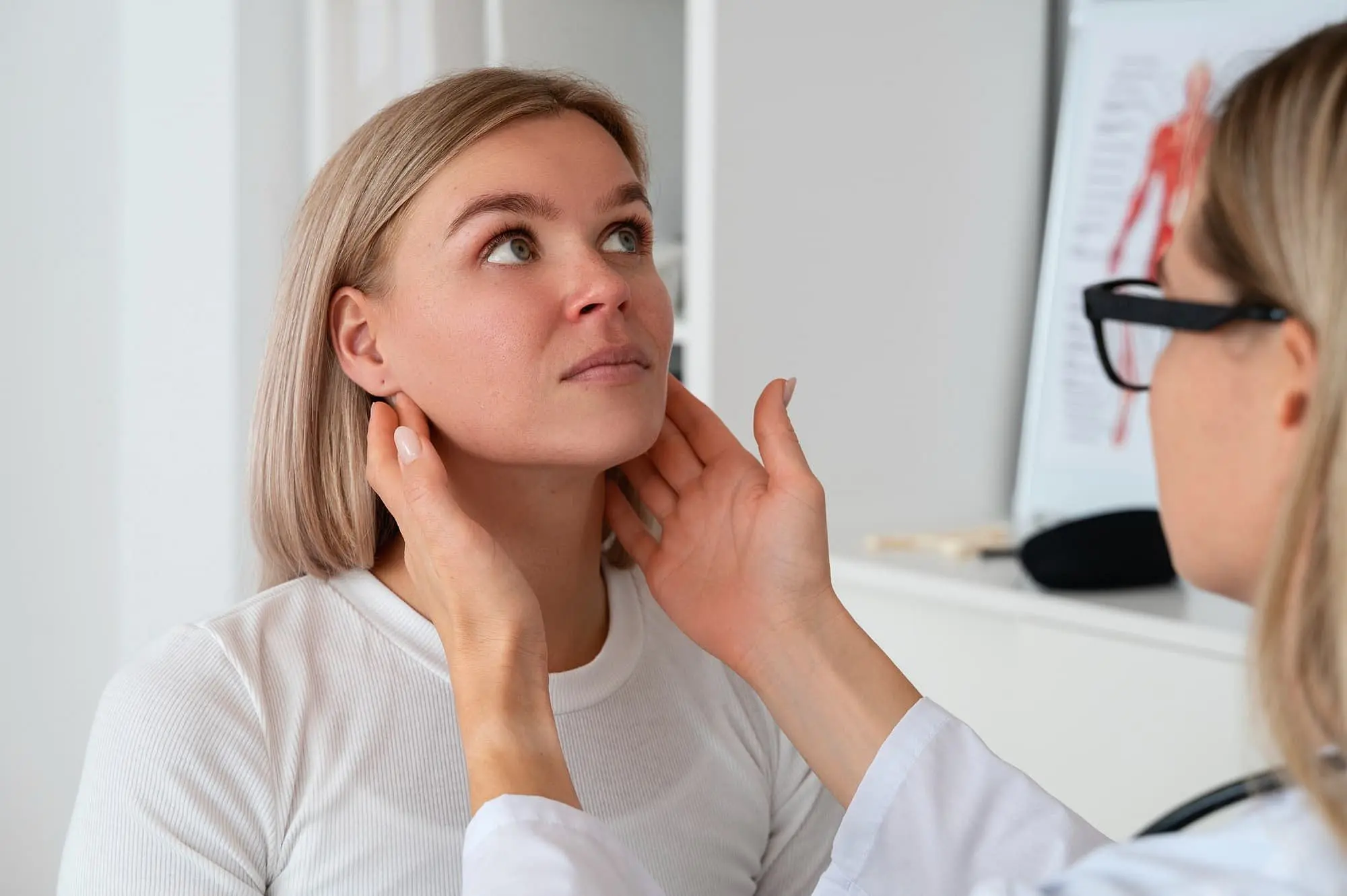 At Holt Orthodontics in Twinsburg, OH, a healthcare professional gently palpates a woman's lymph nodes during a check-up—an important step before procedures such as jaw surgery.