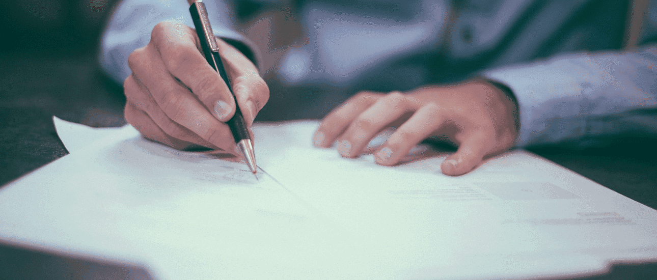 At Holt Orthodontics in Twinsburg, OH, a person reviews orthodontic insurance plans, jotting notes on a sheet of paper.