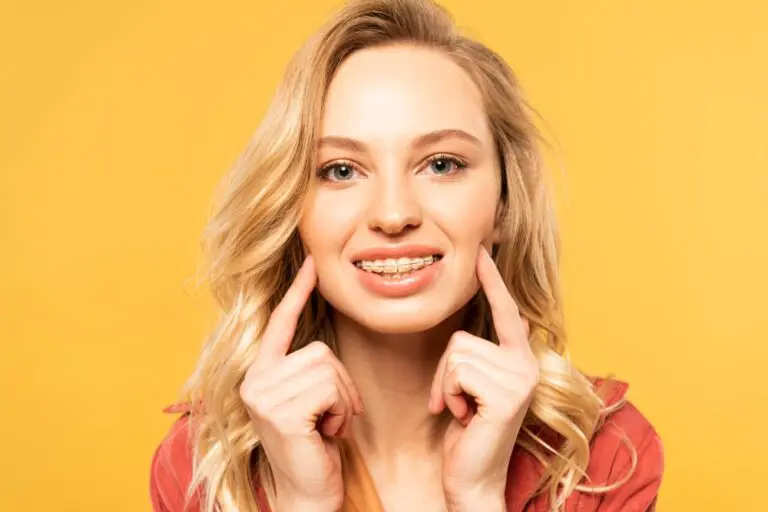 smiling blonde woman clear braces looking camera isolated yellow - Overbite vs Underbite in Twinsburg, OH