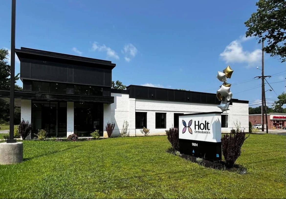 Visit Holt Orthodontics in Twinsburg, OH—a modern white building with a welcoming sign and balloons on the lawn—for your free orthodontic consultation today.