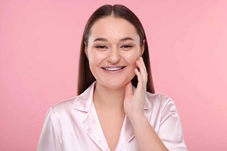 smiling woman dental metal braces pink - Braces for Overbite in Twinsburg, OH.