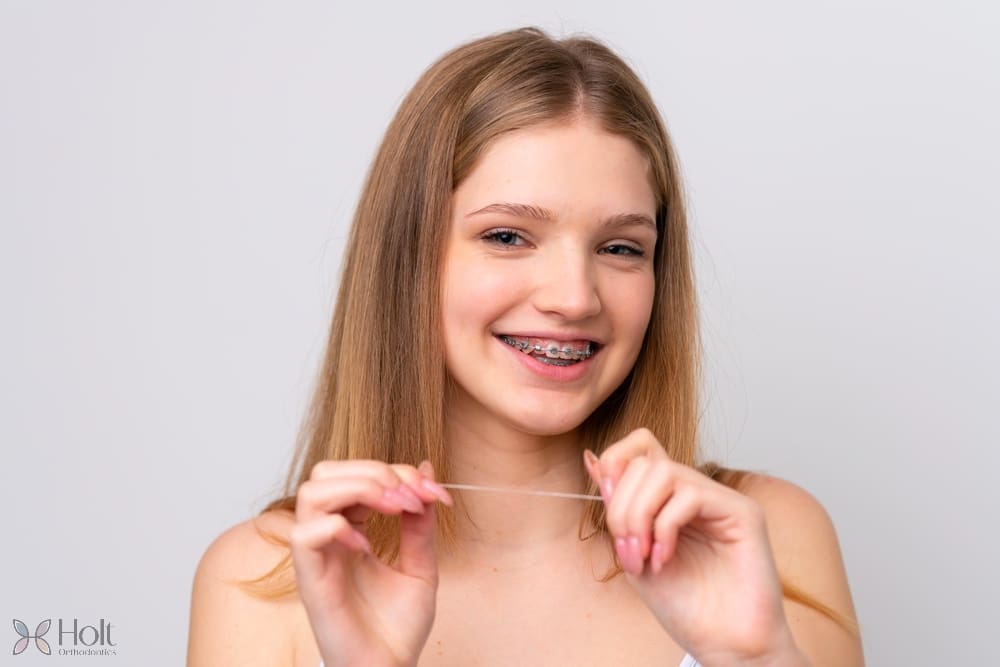 teenager russian girl with metal braces and floss isolated white background - How to Floss with Braces in Twinsburg, OH
